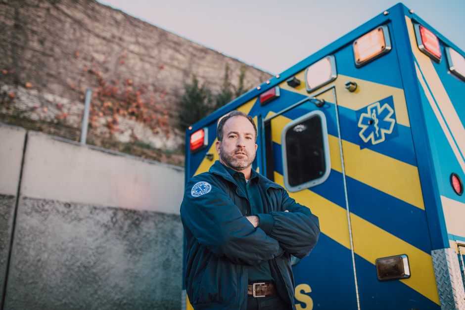 Paramedic standing in front of an ambulance responding to an emergency call