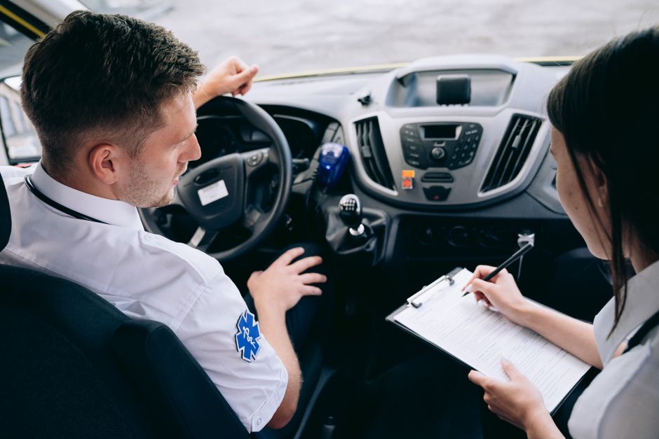 Paramedic team reviewing an emergency call report in an ambulance