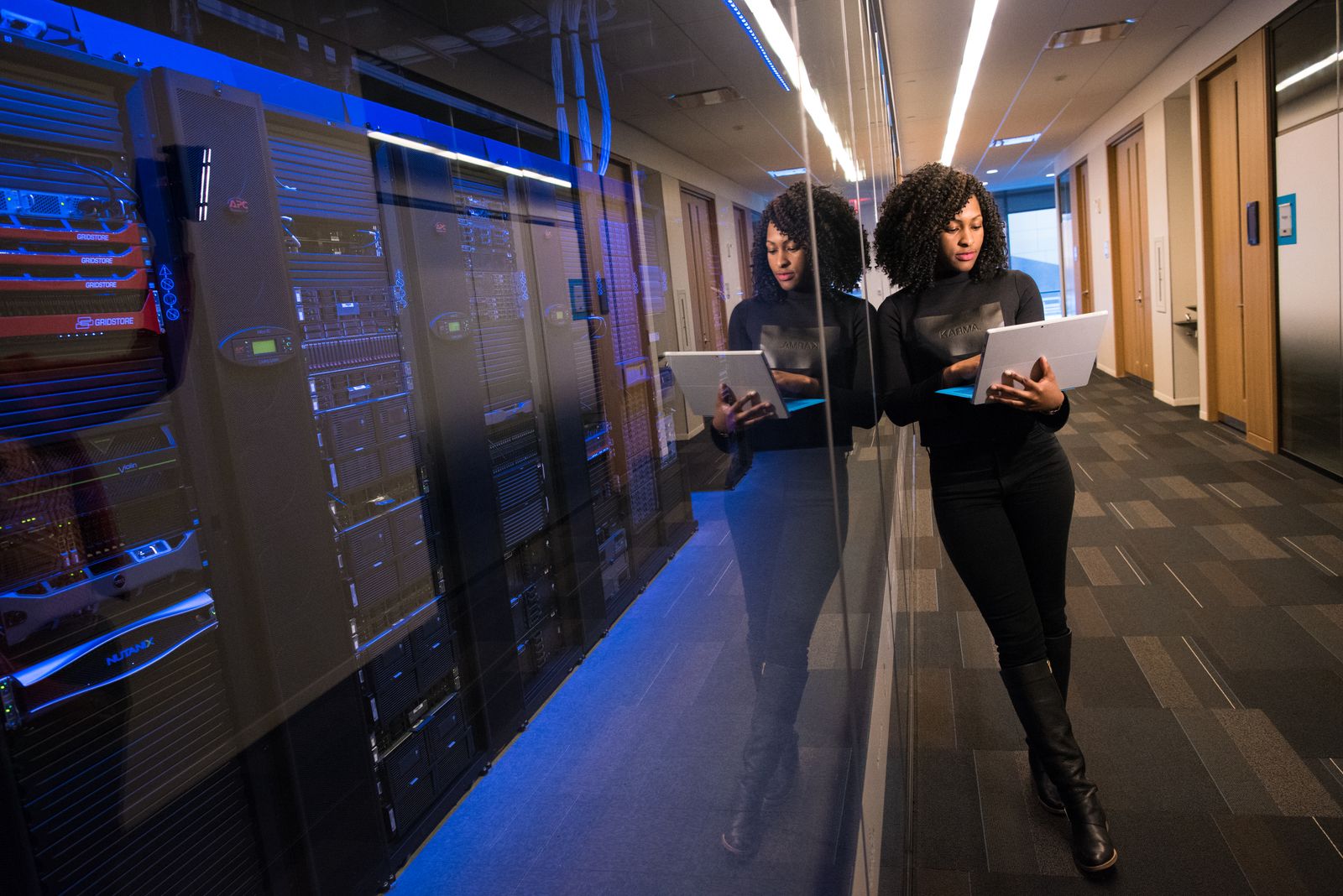 Engineer with a laptop in a data centre corridor