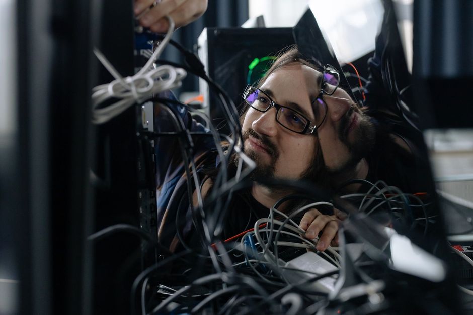 Technician working through network cabling in a server rack